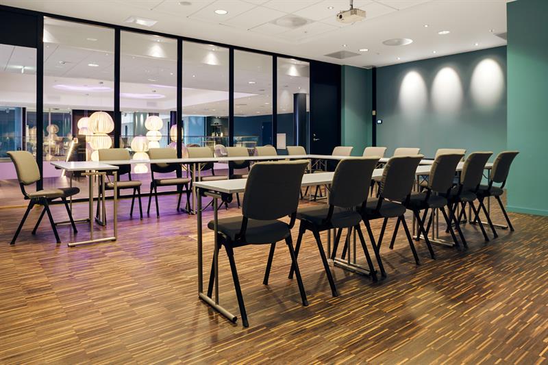 konferansesal med hesteskoformede bord og konferanseteknologi