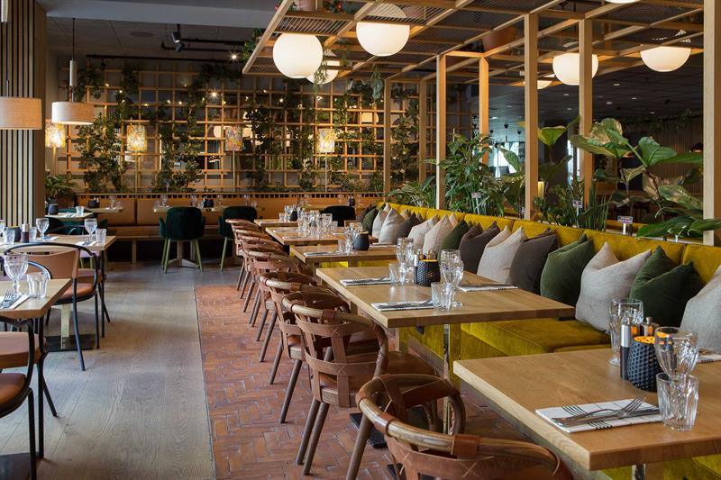 Restaurantinteriør med små bord og sittegrupper