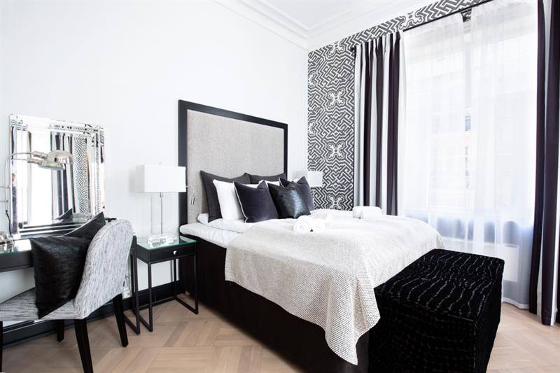 Soverom i svart, grått og hvitt i Frogner House Apartments. Seng, skrivebord