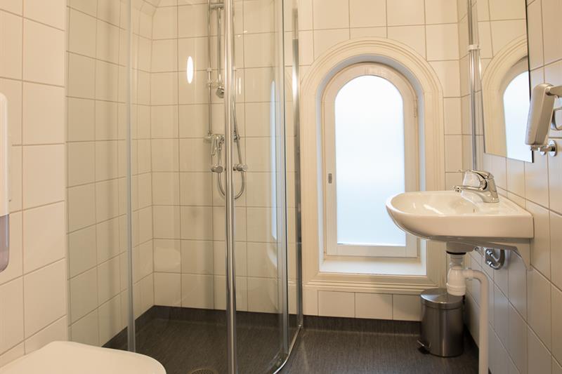 Bad med dusjkabinett i glass. Hvite fliser. Saga Hotel & Poshtel Oslo Central. Foto