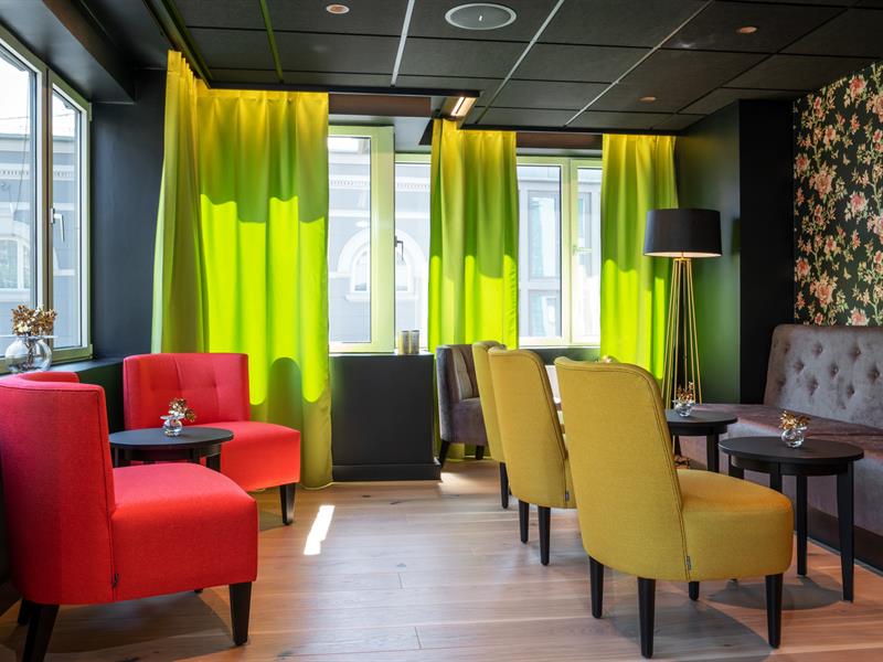 Sittegrupper i rødt og grønt i lobbyen. Thon Hotel Gyldenløve. Foto