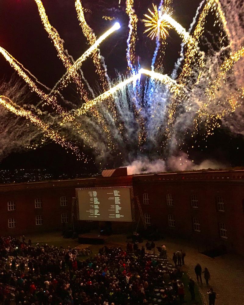 fyrverkeri over festningen og storskjerm og en mengde mennesker