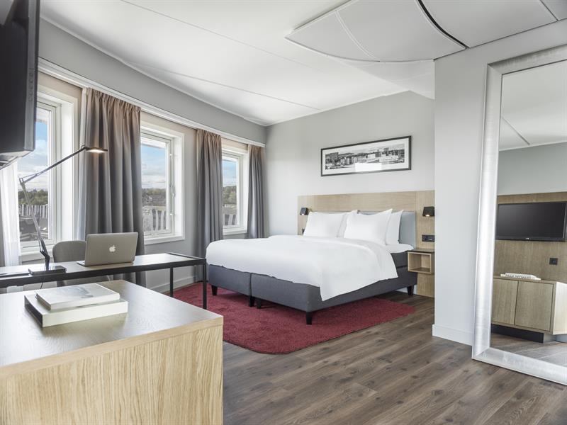 Juniorsuite. Seng, skrivebord og speil i full lengde. Foto