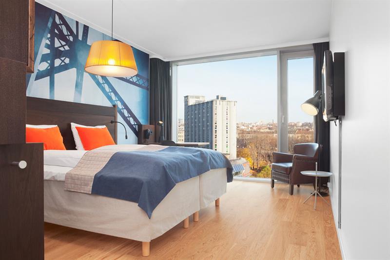 Lyst hotellrom med dobbeltseng og utsikt over Vulkan-området