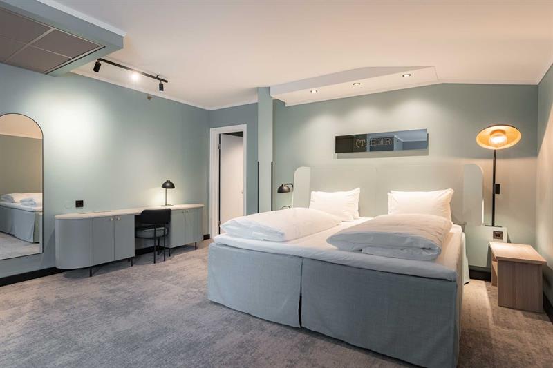 Juniorsuite med dobbeltseng og blågrønne vegger