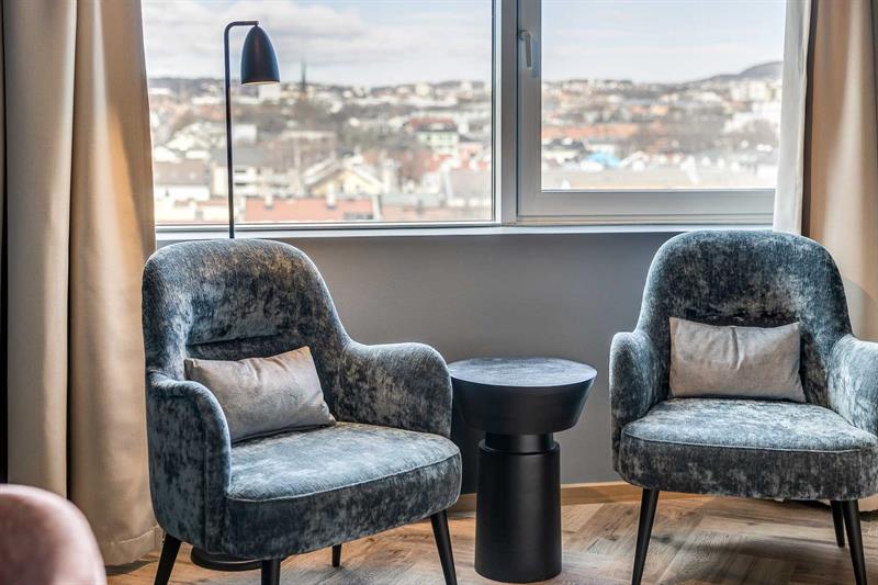 Detalj av to blå lenestoler foran et vindu med utsikt over det nordøstlige Oslo