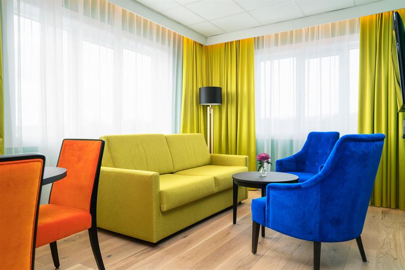 et lyst rom med sofa og lenestoler 