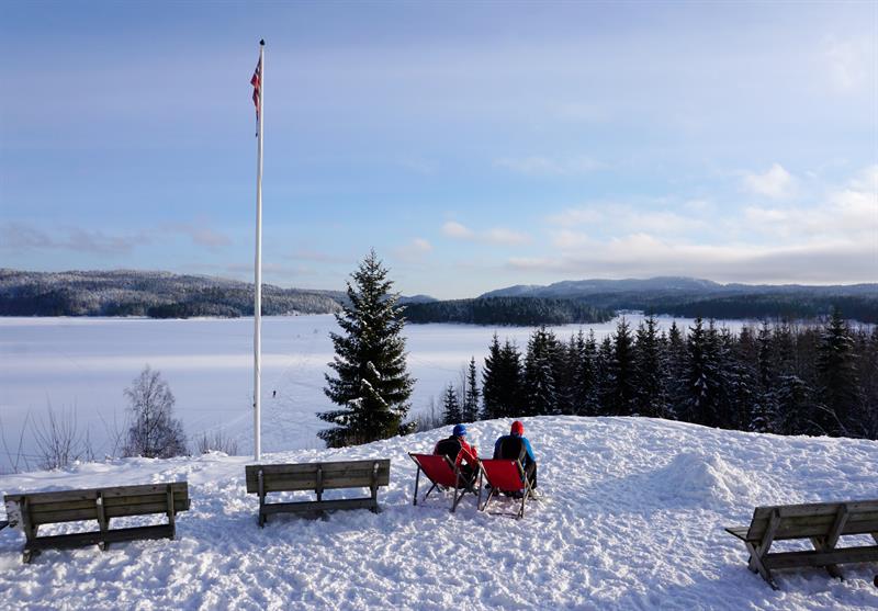 Two people sitting in the snow.