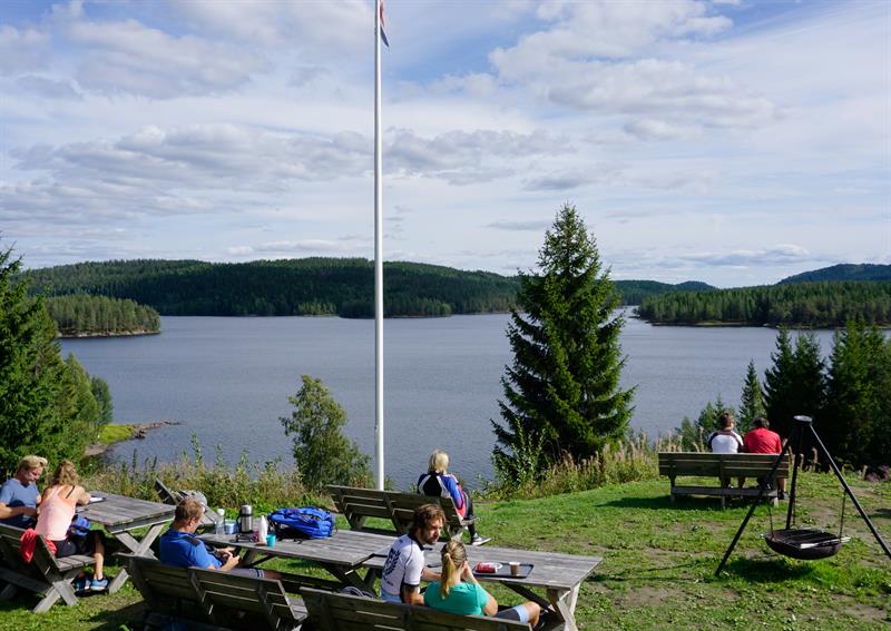 Outdoor seating area with benches and tables, overlooking the lake.