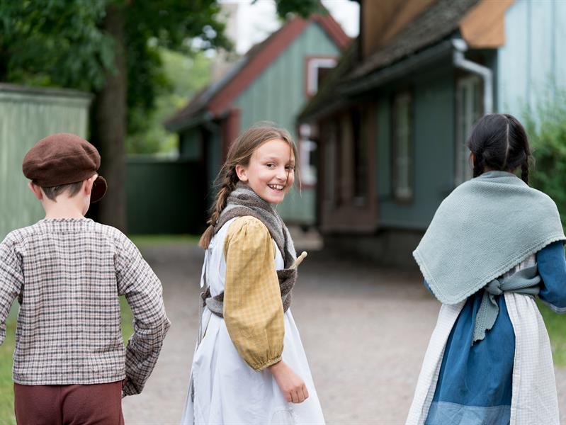 Tre barn i tradisjonelle klær. Norsk Folkemuseum
