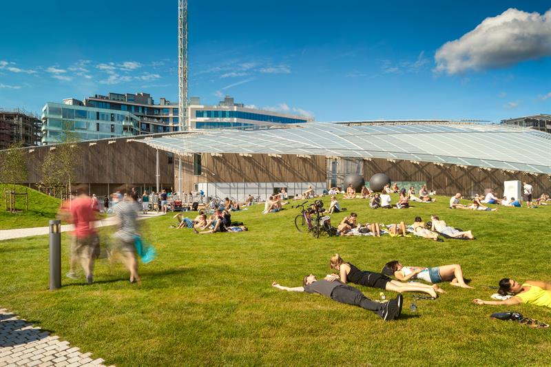 folk som slapper av i gresset foran Astrup Fearnley-museet