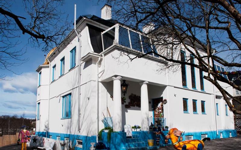 Utsiden av et hvitt trehus.