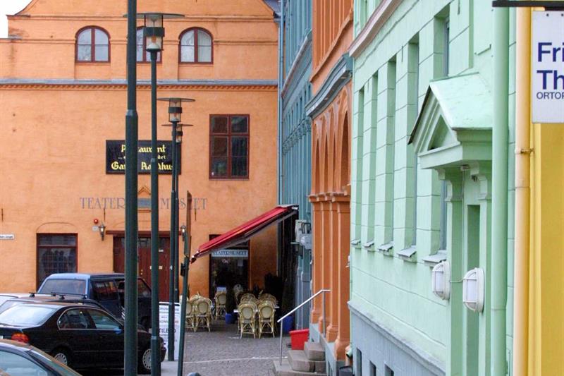 En gate med biler på den ene siden og bygninger på den andre.
