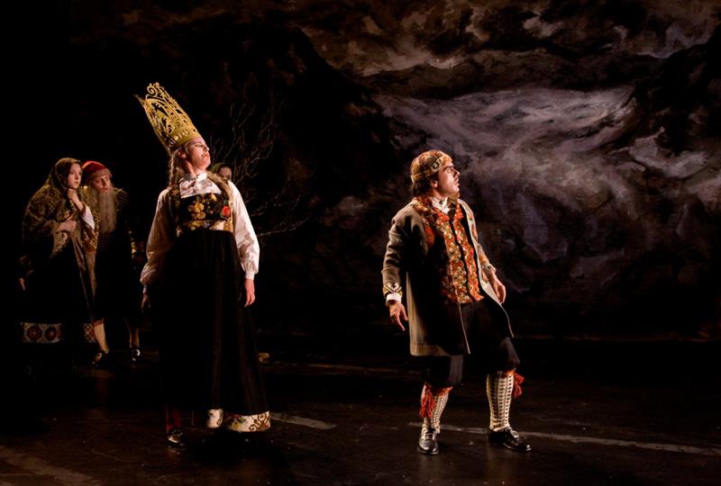 Skuespillere som fremfører et teaterstykke på scenen.