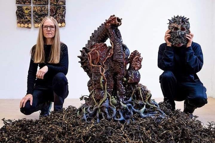 To personer som sitter ved en kunstinstallasjon