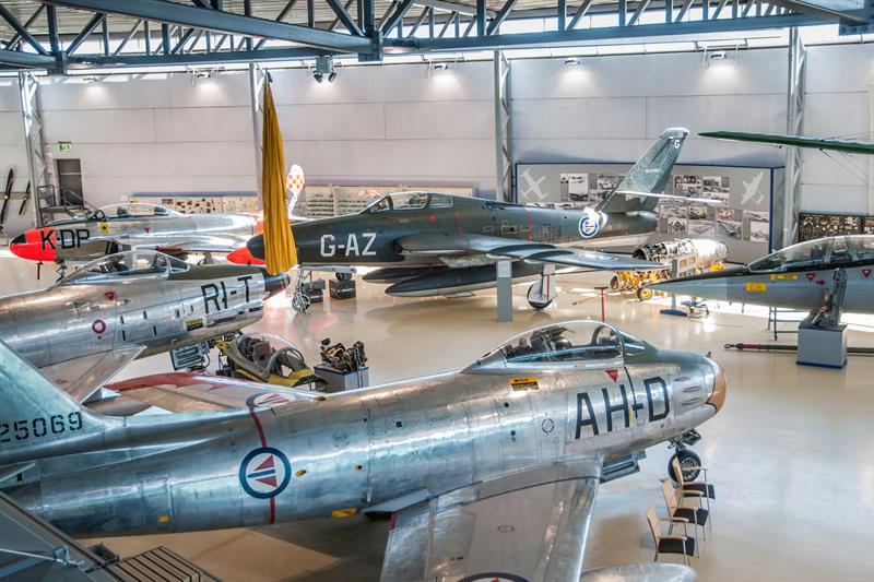 Forskjellige eldre jagerfly i en hangar.