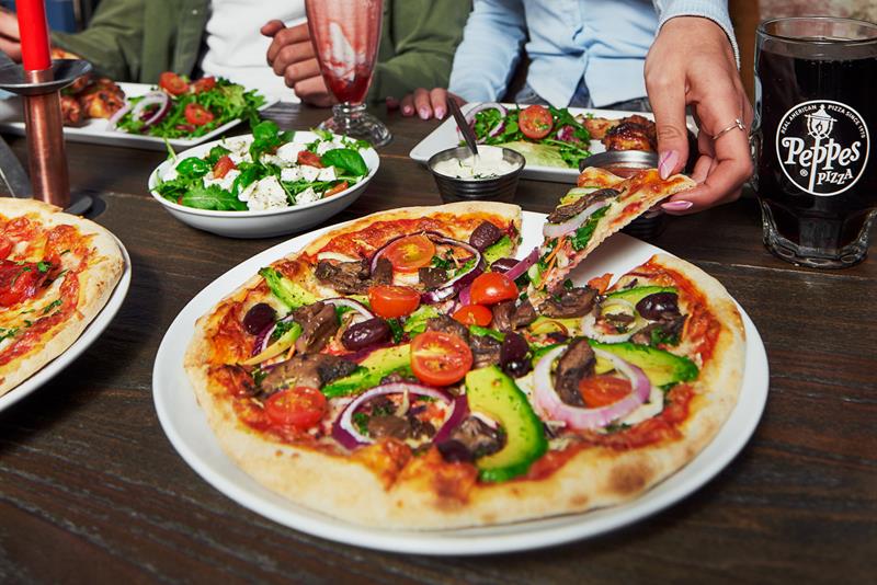 To personer som spiser pizza.