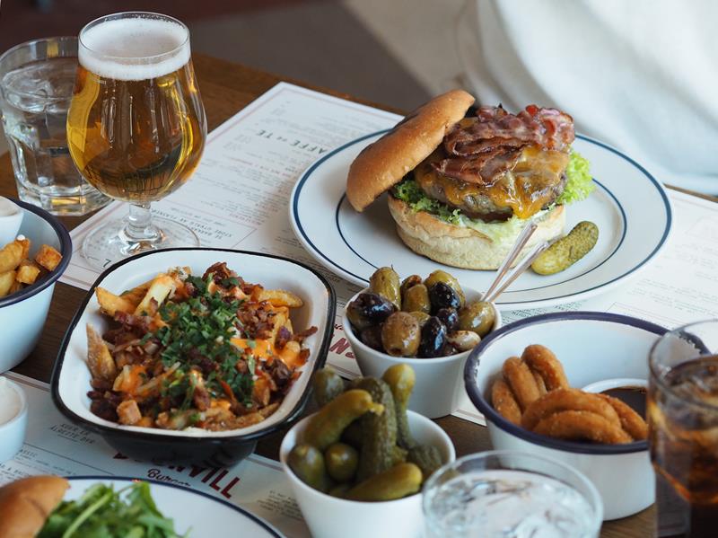 Burger, øl, pommes frites og annet tilbehør.