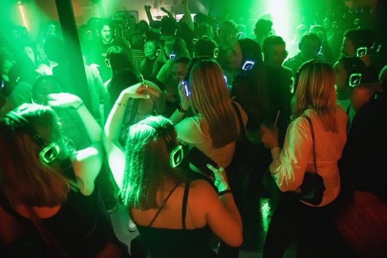 Folk på dansegulvet, omgitt av grønne neonlys