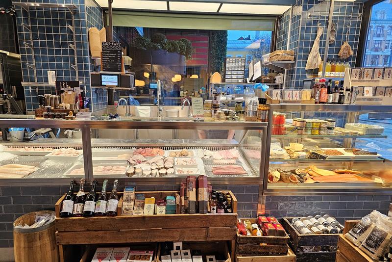 En disk med fersk sjømat, med fisk, skalldyr og gourmetprodukter utstilt i en moderne fiskeforretning