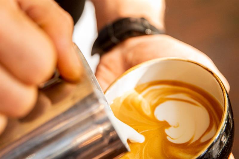 Detaljbilde av tilberedningen av en cappuccino.