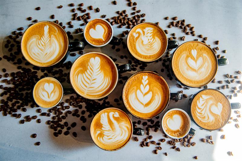Detaljbilde av ulike kopper fylt med cappuccino.