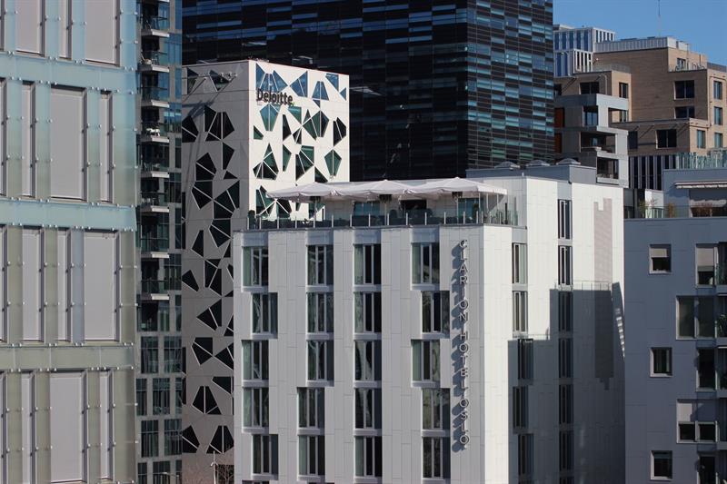 Moderne hotellfasade med takterrasse med utsikt over Oslo sentrum.