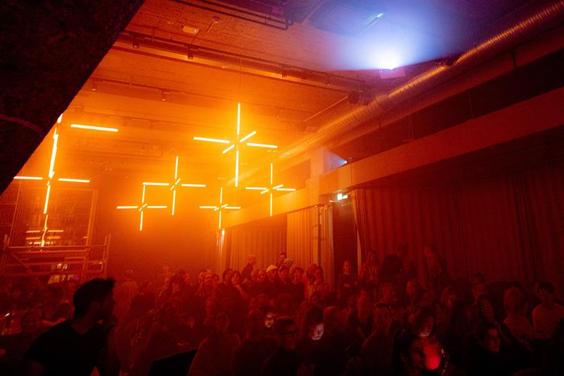 Publikummet som satt foran scenen under oransje neonlys