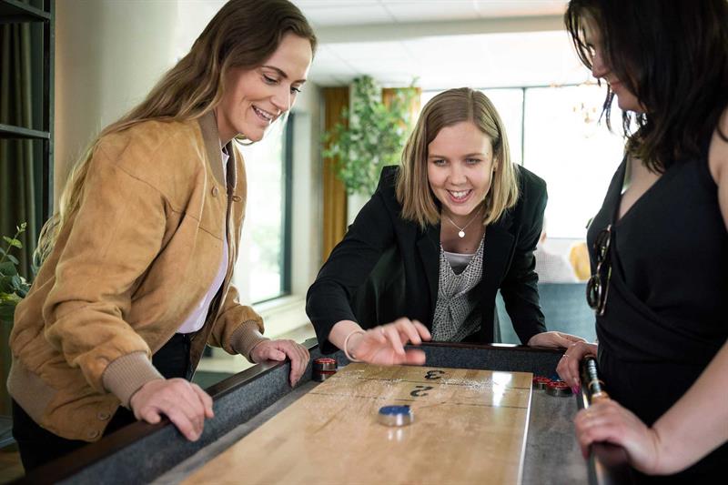 Tre kvinner som spiller shuffleboard