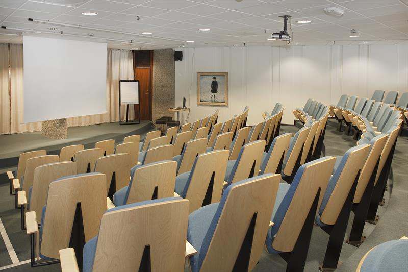 Auditorium med scene og skjerm.