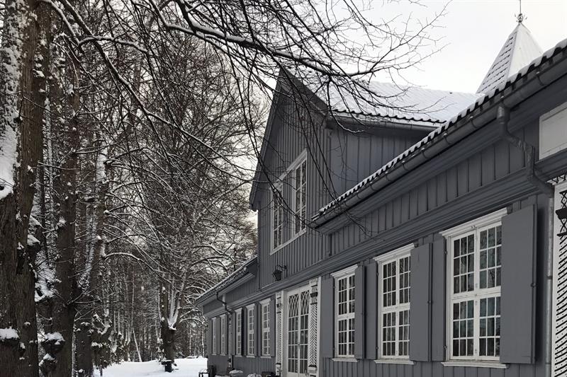 Svart-hvitt bilde av et trehus i snøen.