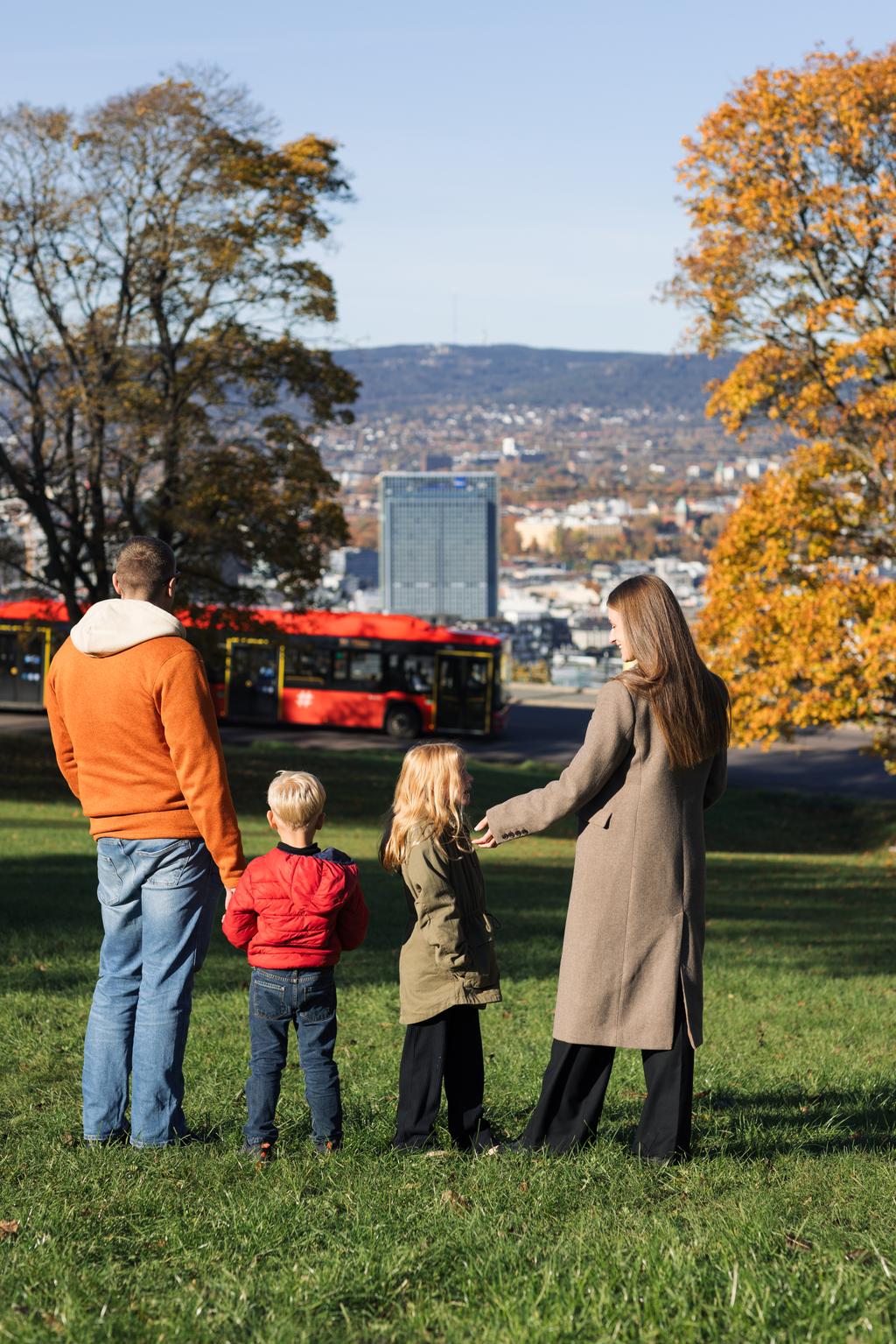 En familie i Ekebergparken som ser ned mot sentrum
