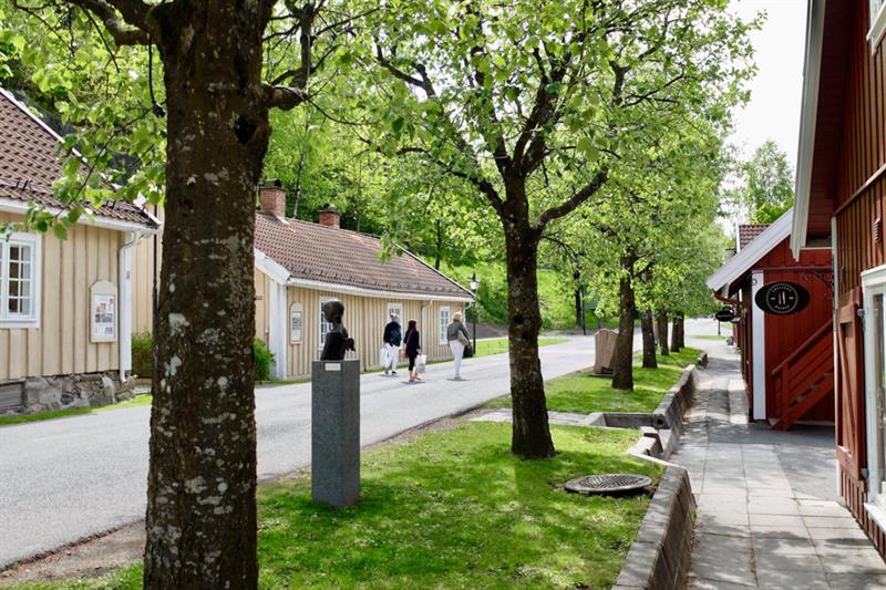 En rekke trehus og grønne omgivelser. Sett fra bakkenivå.