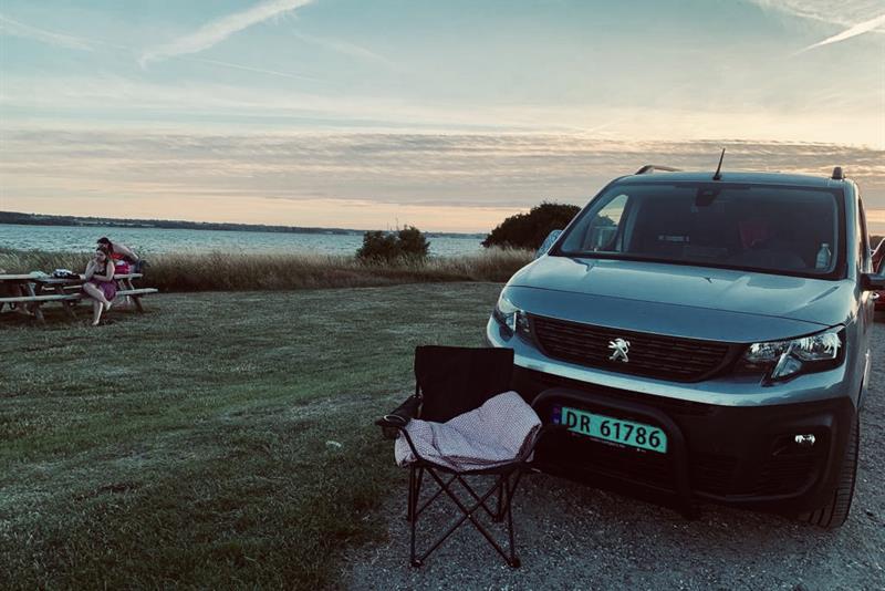 varebil med campingstol foran ved vannet