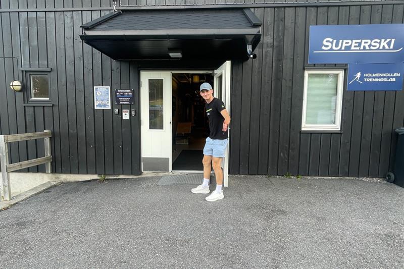 Butikkfasade med en mann som holder døren åpen.