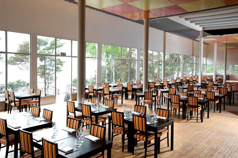 Black tables and striped chairs, large panoramic windows with a good view.