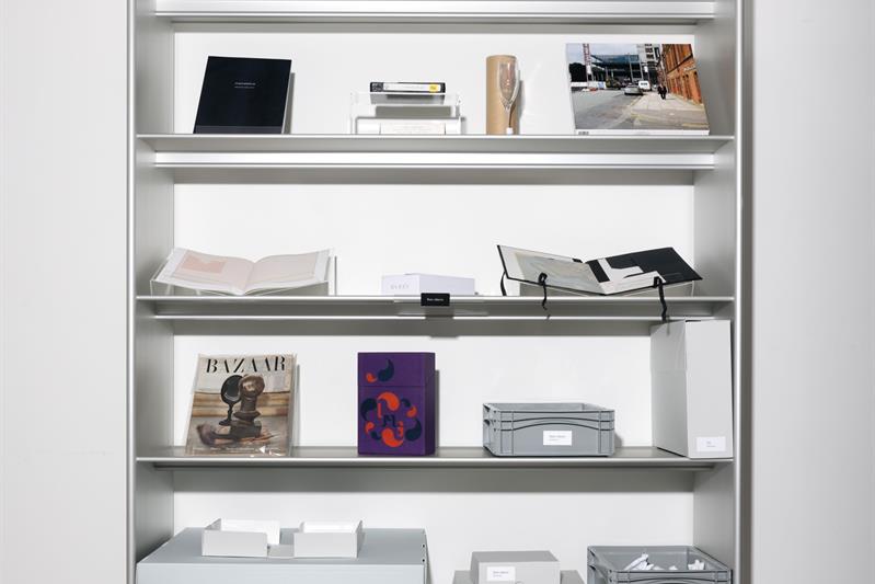 Bookcase with magazines on diplay and gray boxes