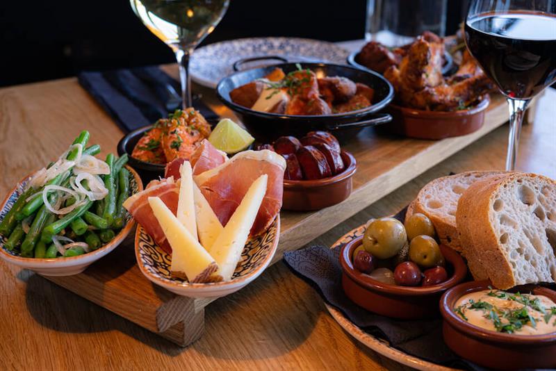 Et utvalg av tapasretter på et bord, fulle vinglass.