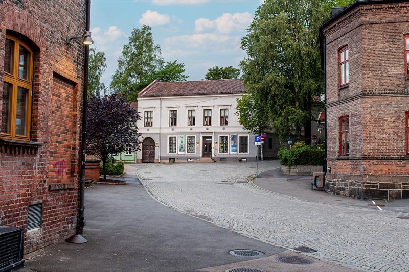 Utsiden av Arbeidermuseet ligger i en rolig brosteinsgate omgitt av historiske murbygninger og trær.
