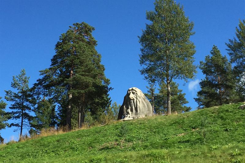 En trollstatue mellom noen trær.
