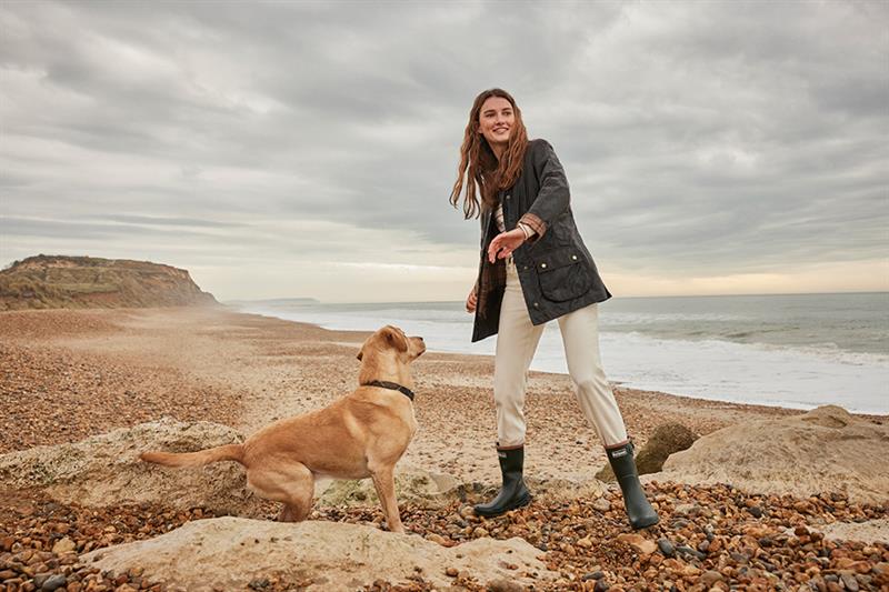 En jente og en hund på stranden