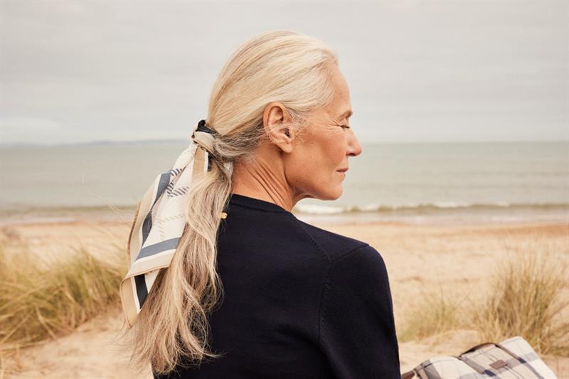 En kvinne sitter ved stranden