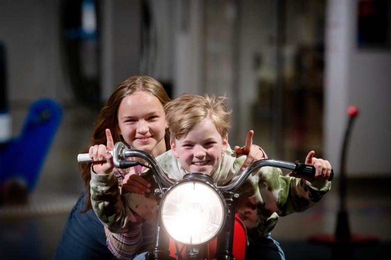 To barn sitter på en motorsykkel