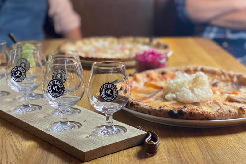 Detalj av pizzaer og tomme ølglass.