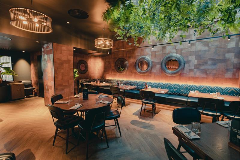 Restauranten, varme toner, grønne planter som henger fra taket