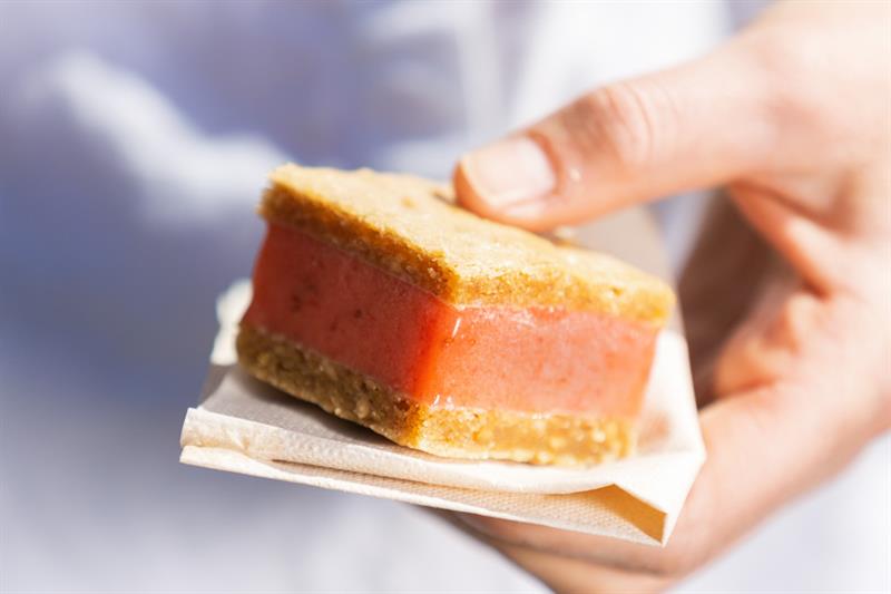 noen som holder et iskremsmørbrød