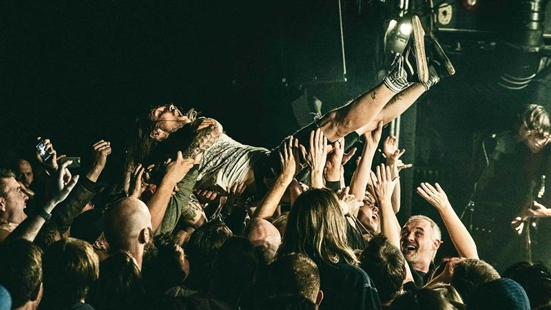 Mann crowdsurfer under konsert
