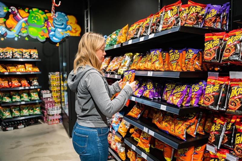 jente velger produkter fra godterihyllen