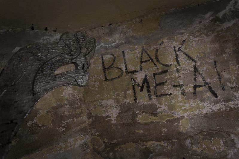 "Black Metal" og et dragehode tagget på en vegg.