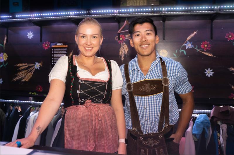 To ansatte iført lederhosen jobber i garderoben